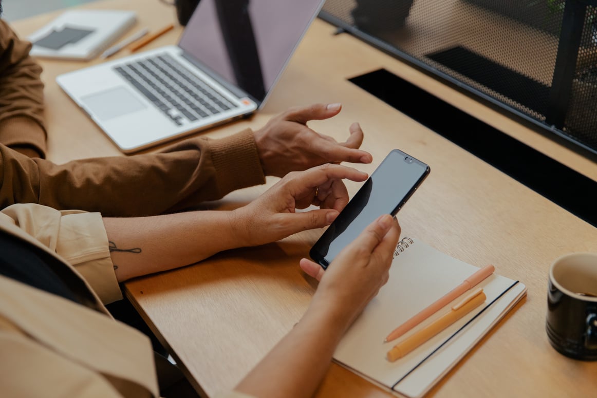 Two Business Colleagues Using Smartphone and Laptop